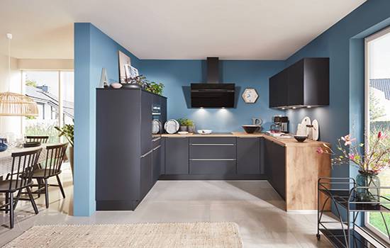 Cuisine moderne noire et bois avec mur bleu – Réalisation signée Wood'IT Cuisine contemporaine en L avec façades noires mates et mur bleu – Conception Wood'IT